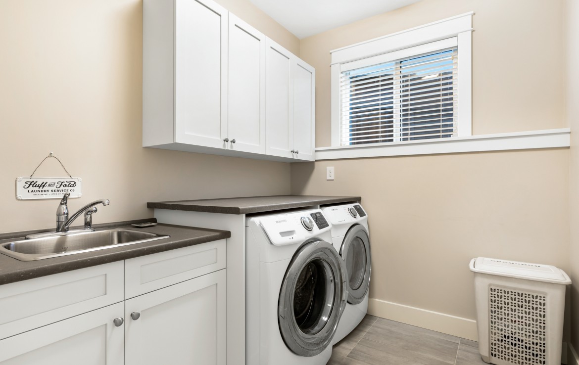 Laundry room with folding space, sink and storage.