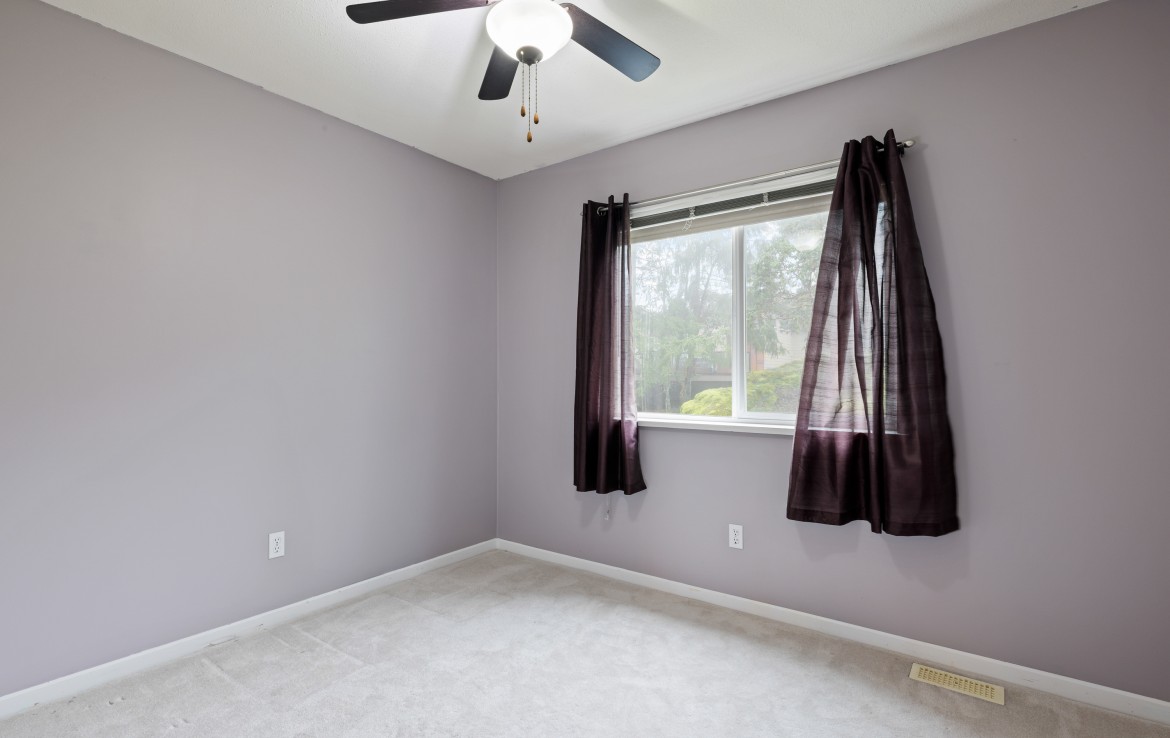 Additional bedroom with window and ceiling fan.