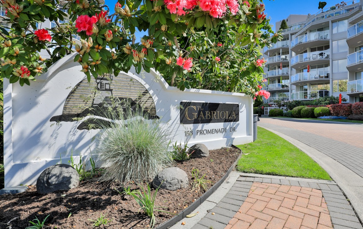 Side angle of the Gabriola sign with a condo building.