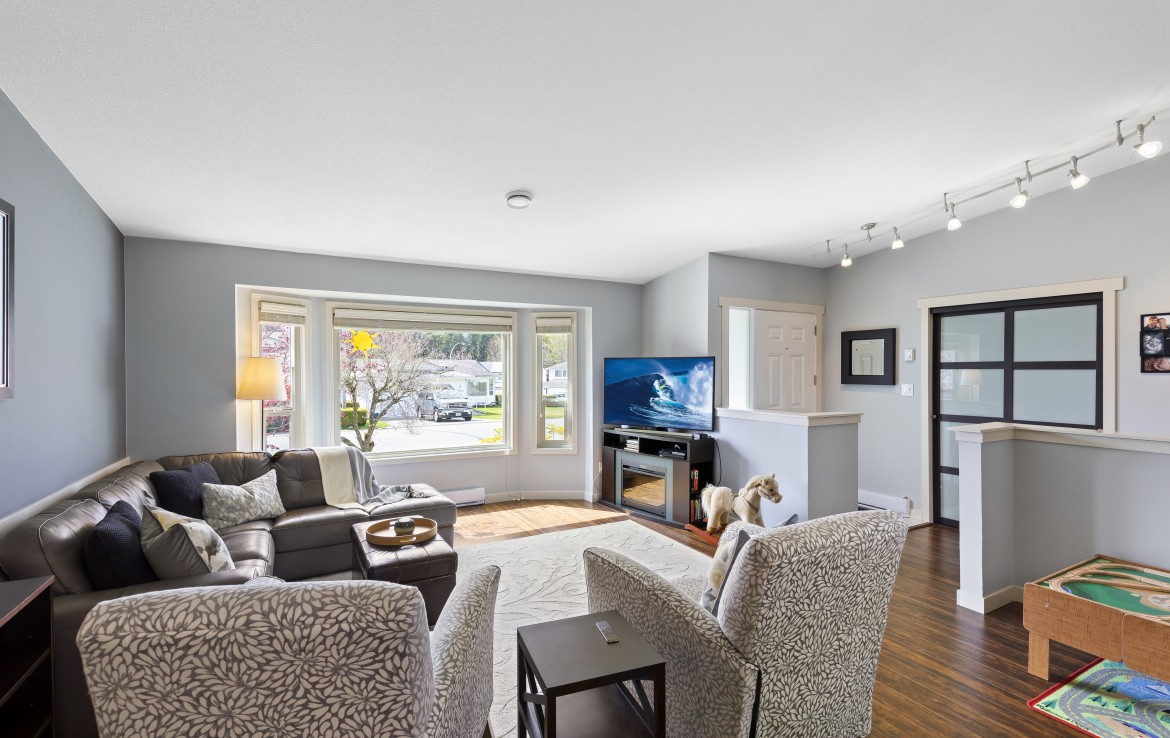 Living room view with bay windows and vaulted ceilings. Nadely, Nanaimo, BC.